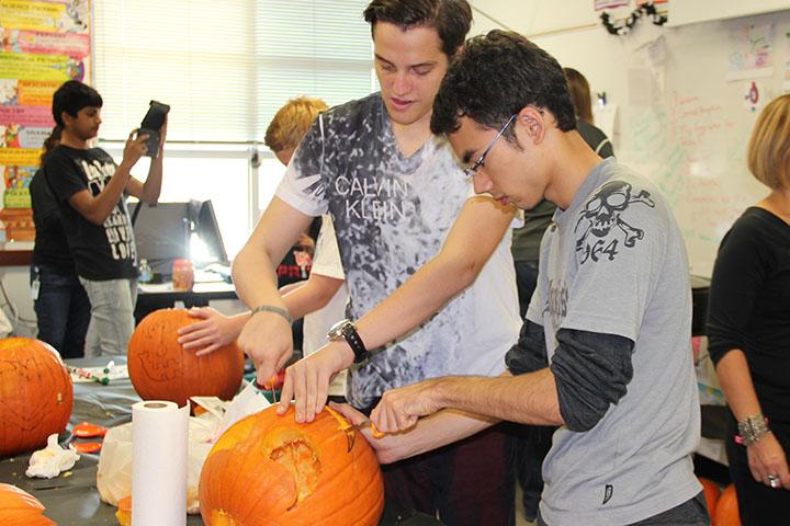 Derya+Yilmaz+and+Yuro+Sato+carve+a+pumpkin+during+the+ESL+cultural+celebration.+