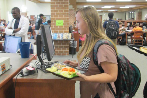 Junior Katie Buschang signs into the library during lunch.