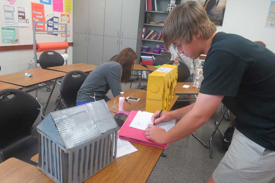Sophomore Latin student Christopher McKenzie draws another students project.