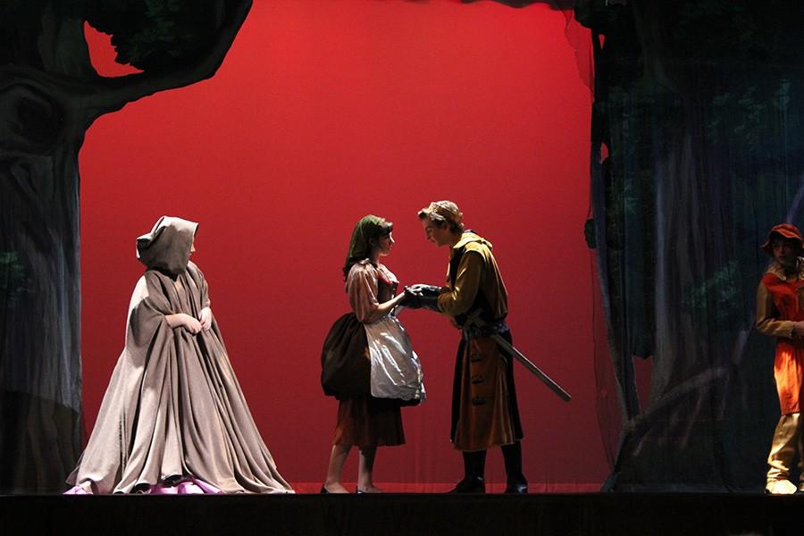 Prince Topher meets Cinderella in the woods during the first act while her fairy godmother looks on. 