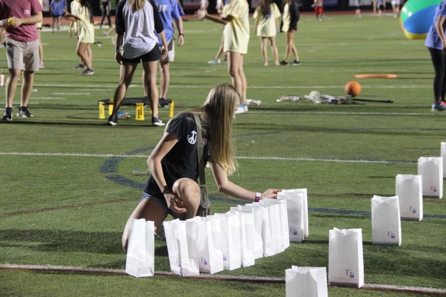 A student begins to display the luminara lights for the upcoming ceremony.