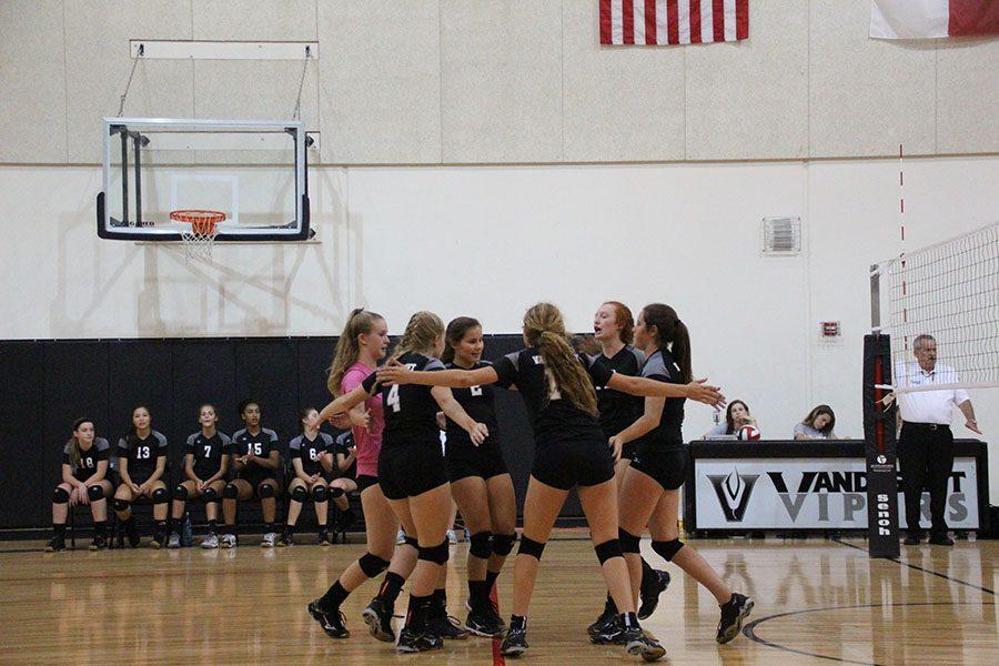 The freshman volleyball team celebrates after winning a point against Bowie