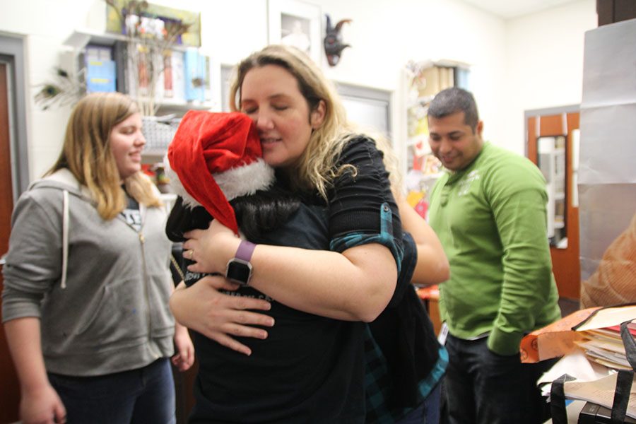 Teacher Nikki Guckian hugs an AD Team member as she was given the poinsettia.