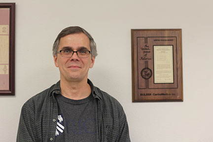 Martin Wiedenmeier standing next to his patent. Wiedenmeier patented his idea for testing heart valves back when he was a biomedical engineer.