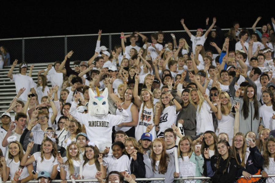 Students celebrate a touchdown at a football game.