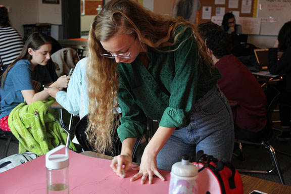 Senior Hannah Barnard works on a poster during a Women's Rights Club Meeting. The club started this school year. Natalie Brink photo