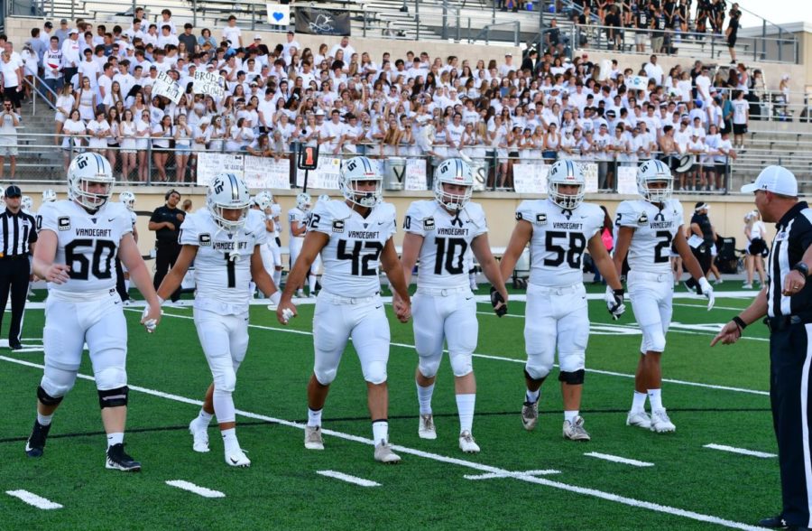 Football captains walk onto the field during a game