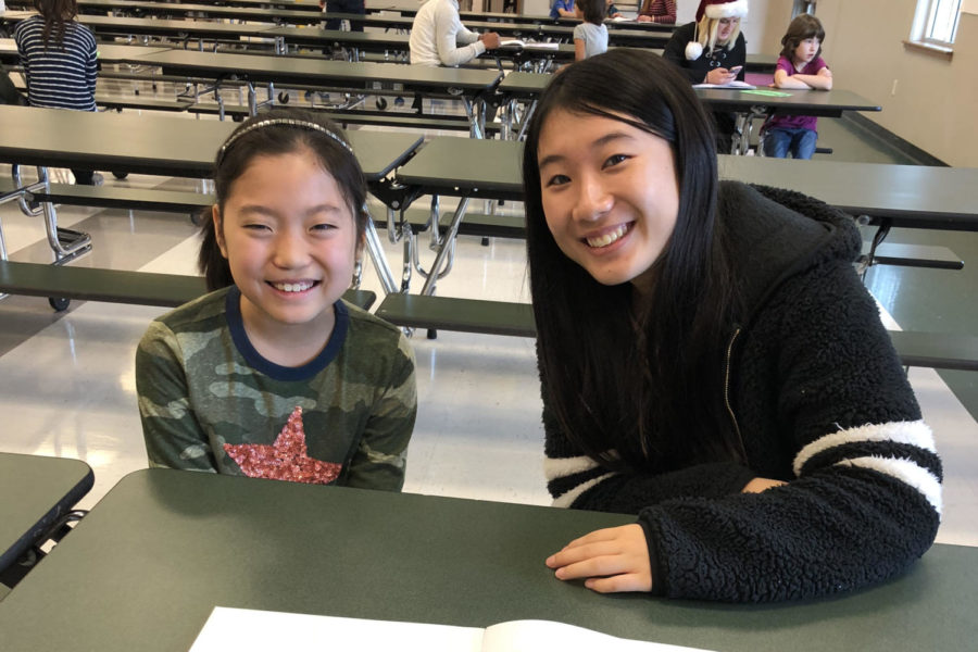 Sophomore Aoi Nishimara reads her story to EL elementary student.