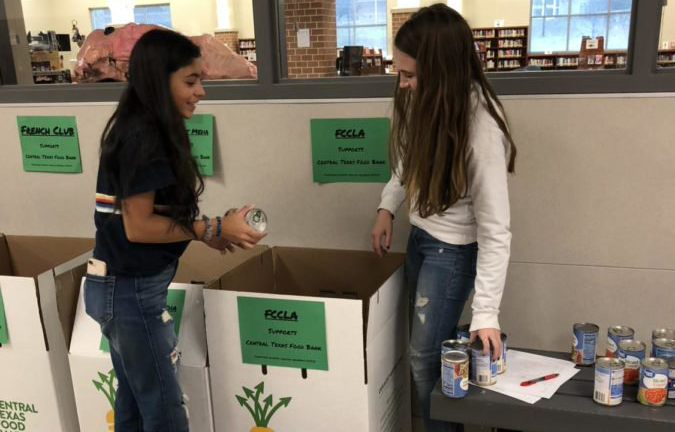 Students+donate+to+the+FCCLA+canned+food+drive+box.