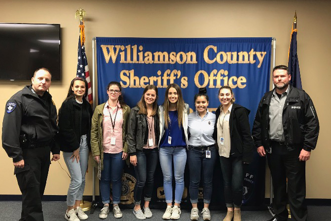 Senior Alexandra Spears takes a group picture with other COOL Week students and officers from the Jonestown Police Department.