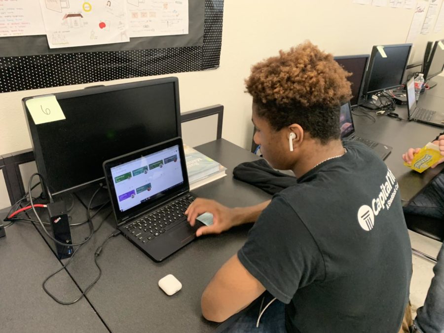 Senior Issac Haggins listens to music through his AirPods while he works 