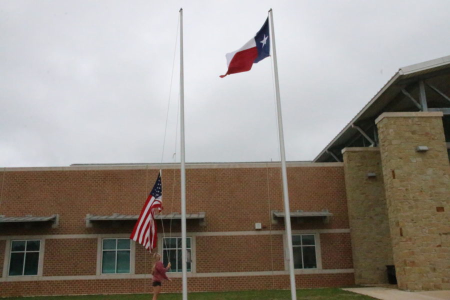 Senior Sonya McCann raises the flags during fifth block as one of the many jobs the front office aides have. “Me and Keaton Field have gotten it down to a science and we’re able to do it in 2 minutes, but I’ve learned to do it on my own because Keaton hasn’t been here,” McCann said.