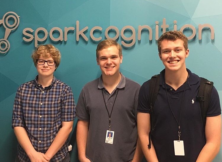 Senior Landon Palmer (far right) standing in front of Sparkcognition’s logo with other students participating in LISD’s COOL week. 