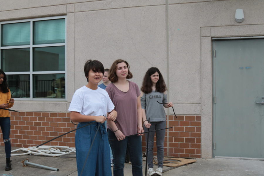 Junior Julia Krupp and senior Megan Gordon use PVC pipes and branches to work on Art Clubs Earth Day project during PIT. I love that we just get to come together and create outside of an art class. We can just do creative stuff and express ourselves, Gordon said.