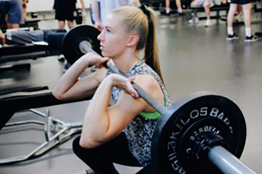 Senior Ina Edstrom lifts weights in the weight room during practice.