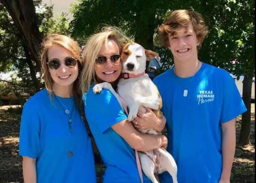 Olivia, Christian, and their mother with a dog up for adoption from the Texas Humane Heroes at an event.