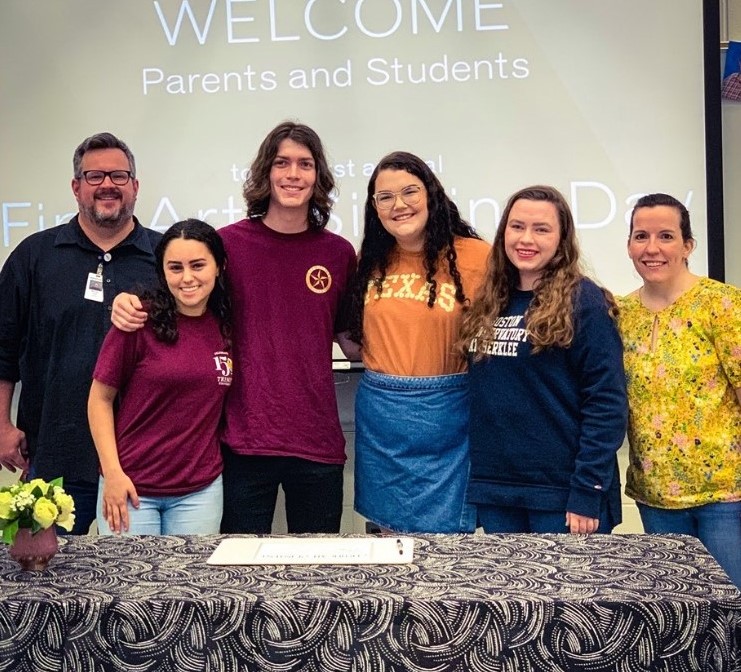 Seniors stand with choir directors Michael Zook (left) and Megan Goodman (right) on  the fine arts signing day.