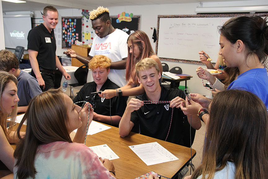 Junior Mason Arsenault (left) and Blake Litzau (right) make paracord bracelets to be shipped to soldiers overseas. 