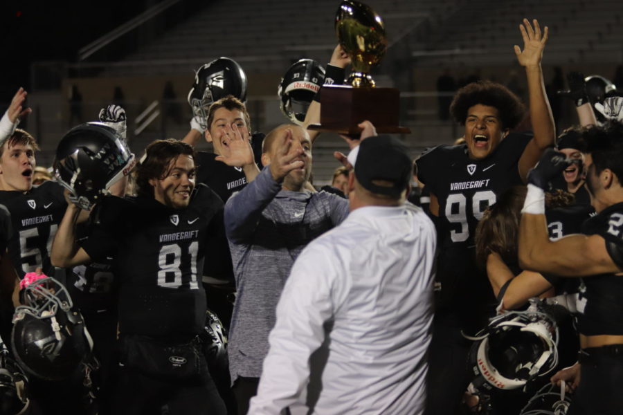 Coach+Sanders+and+varsity+players+celebrate+their+victory.