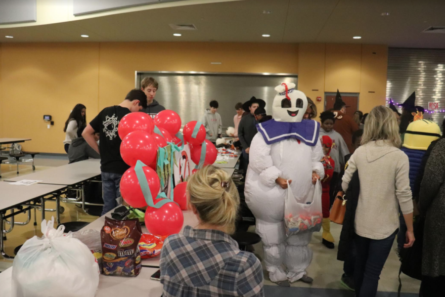 Freshman Karina Brown hands out candy to children surrounding the Ghostbusters themed robotics trunk.