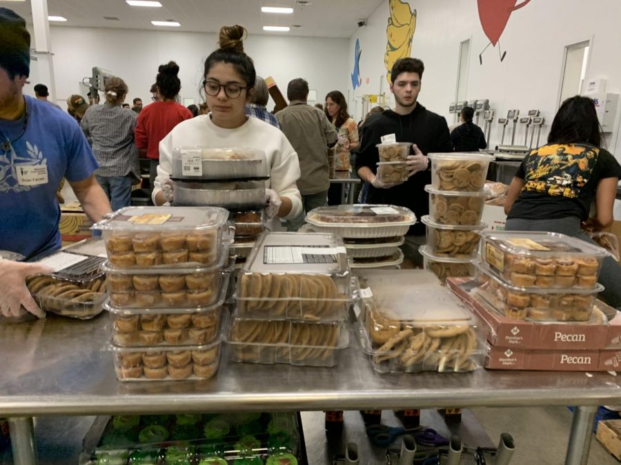 Junior Marah Santiago (left) and Ethan Odom (right) sort food into meal boxes.