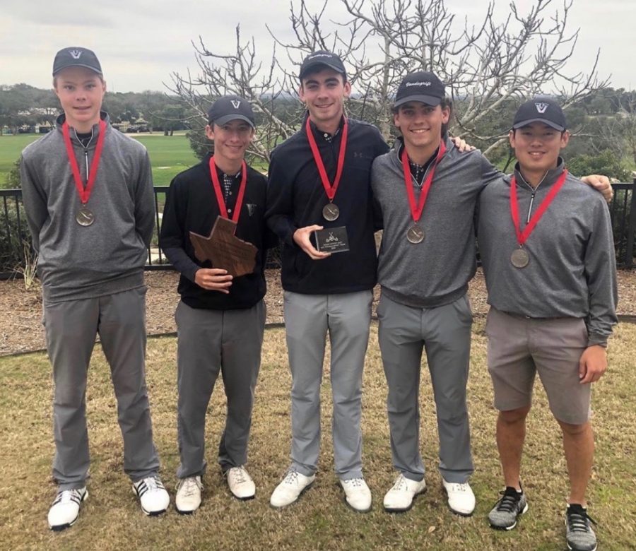 Boys golf players stand with awards and medals after tournament. 