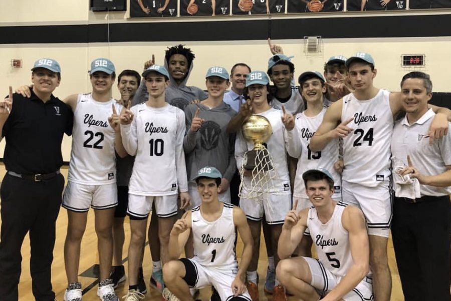 The basketball team poses after being named district champions.