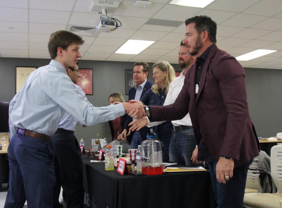 After presenting with his team, senior Jack Conlon shakes hands with real estate agent Gene Arant. 