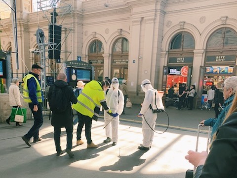 Students godmother watches officials clean a train station in Budapest earlier in the week.