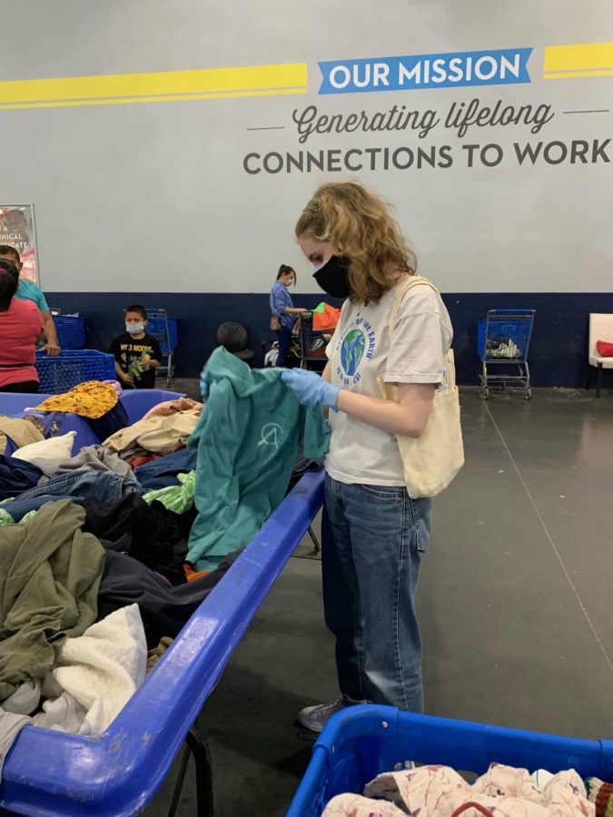 Senior Audrey Kimball gets recycled fabric at a Goodwill bin.