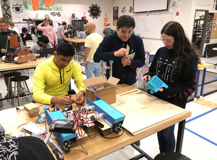 Riley Galligher, far left, works with her robotics team as a project manager. 