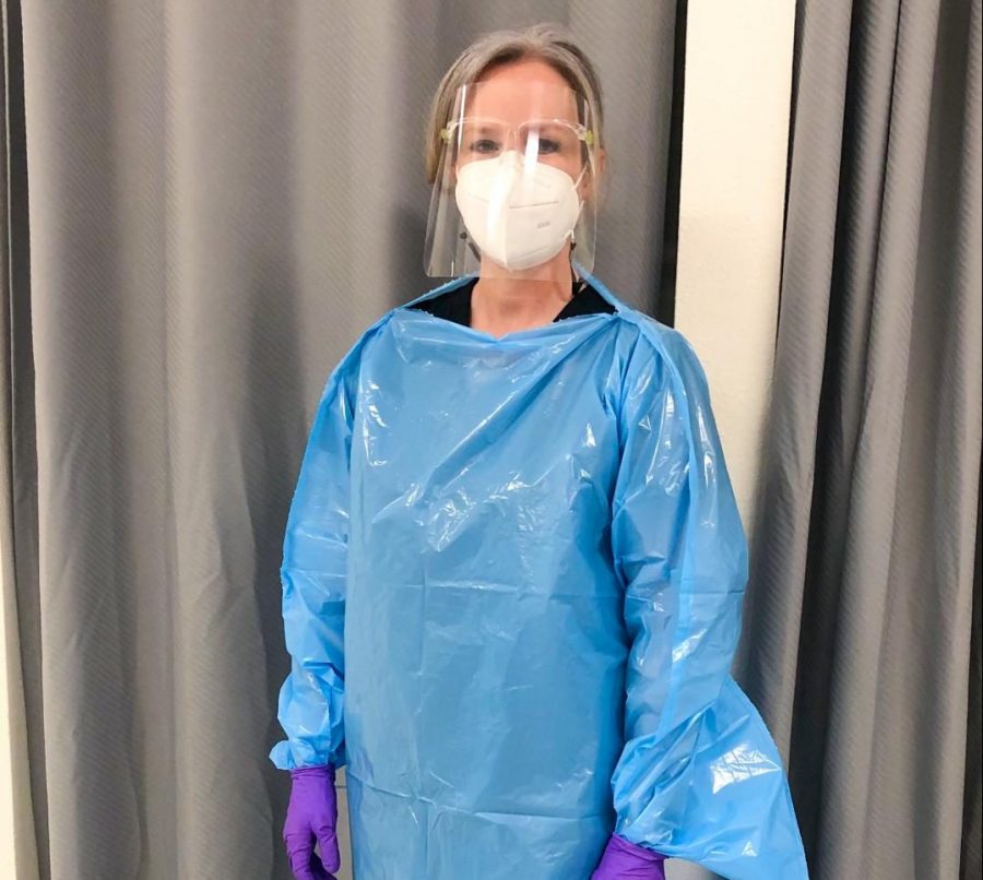 Vandegrift school nurse Jamie Ennis poses in her office wearing all of her protective gear.