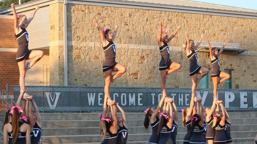 Varsity Cheerleaders practice their stunts before the game begins.