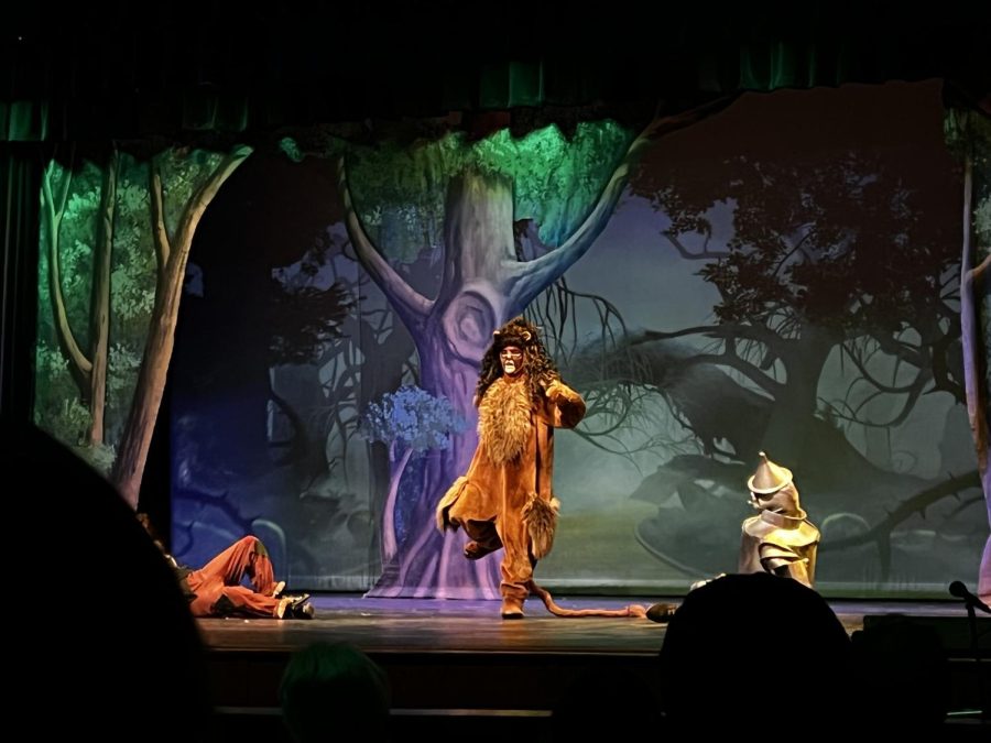 Cowardly Lion (Raine Collier) performs her number upon meeting Dorothy an d her friends