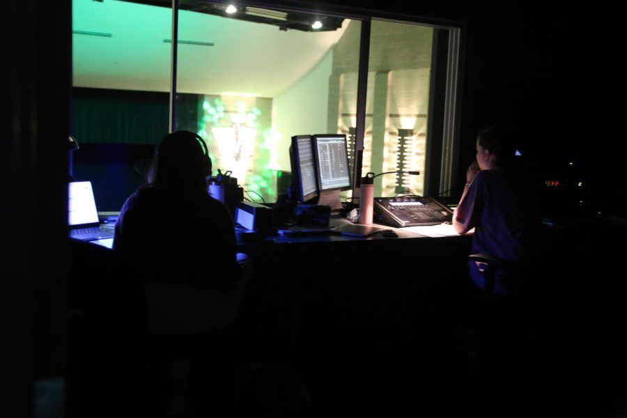 Beth and Brooke sit together up in the lighting booth, doing their jobs