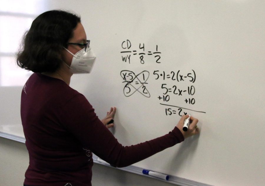 Advanced Algebra II/Geometry teacher Katy Seloff demonstrates a problem on the board for her class.