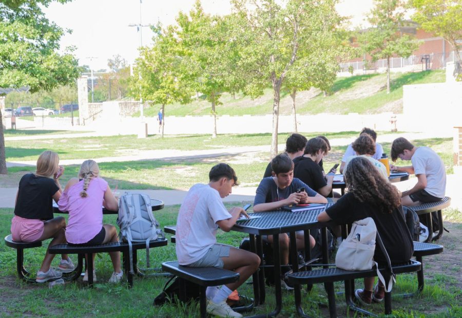 During a power outage, students sit outside due to fluctuating temperatures in classrooms. 