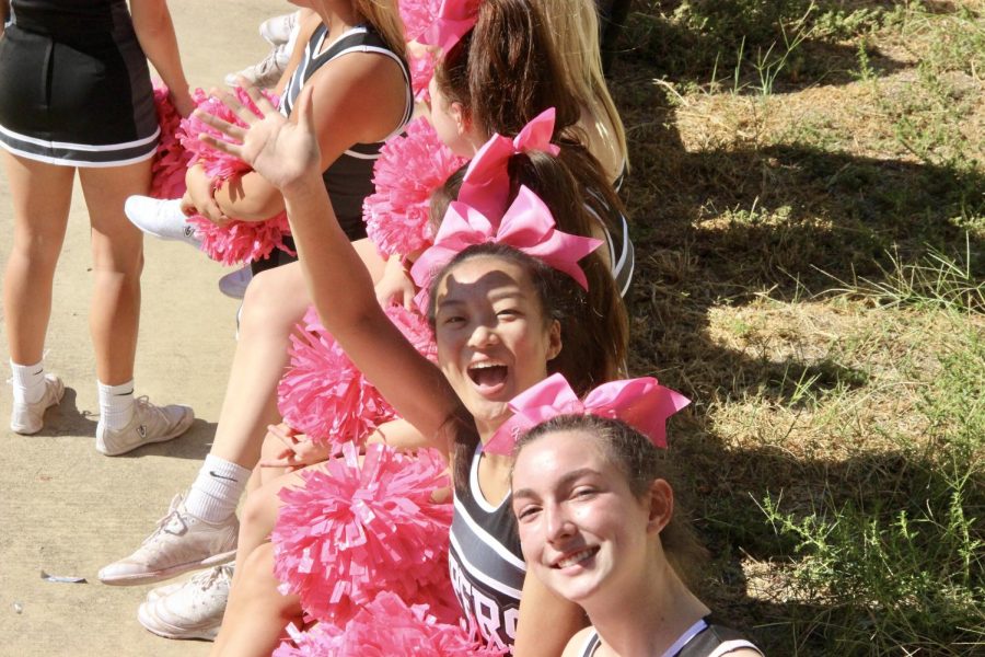 Seniors cheerleaders Cady Wong and Kathryn Frazier wave to students surrounding the courtyard.