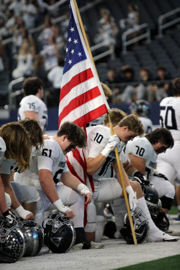 The team gathers together as is tradition with senior wide receiver Braden Agnew holding the American flag.