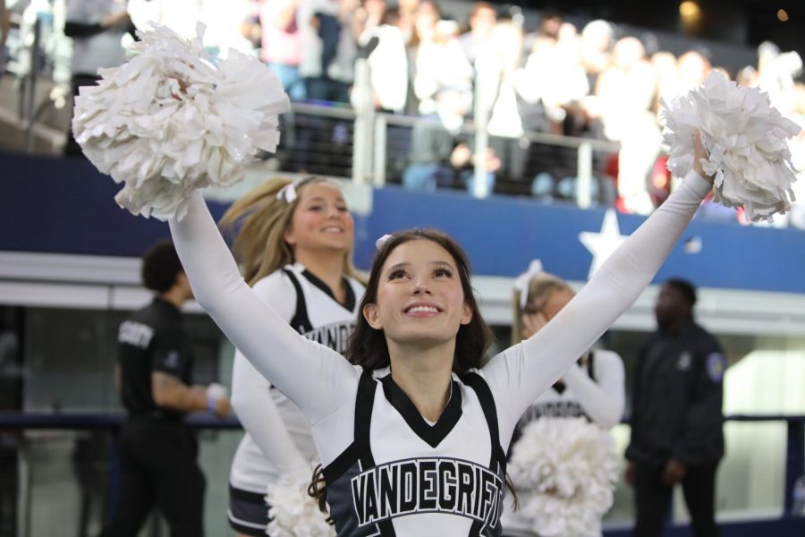 The cheer team performed behind the players in front of the students and parents.