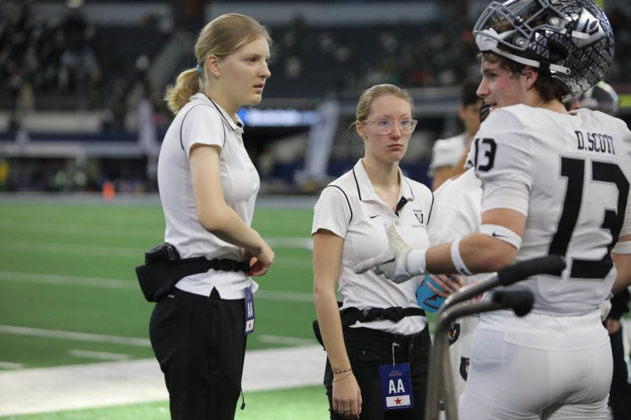 The sports med team attends to senior Davis Scott on the sideline.