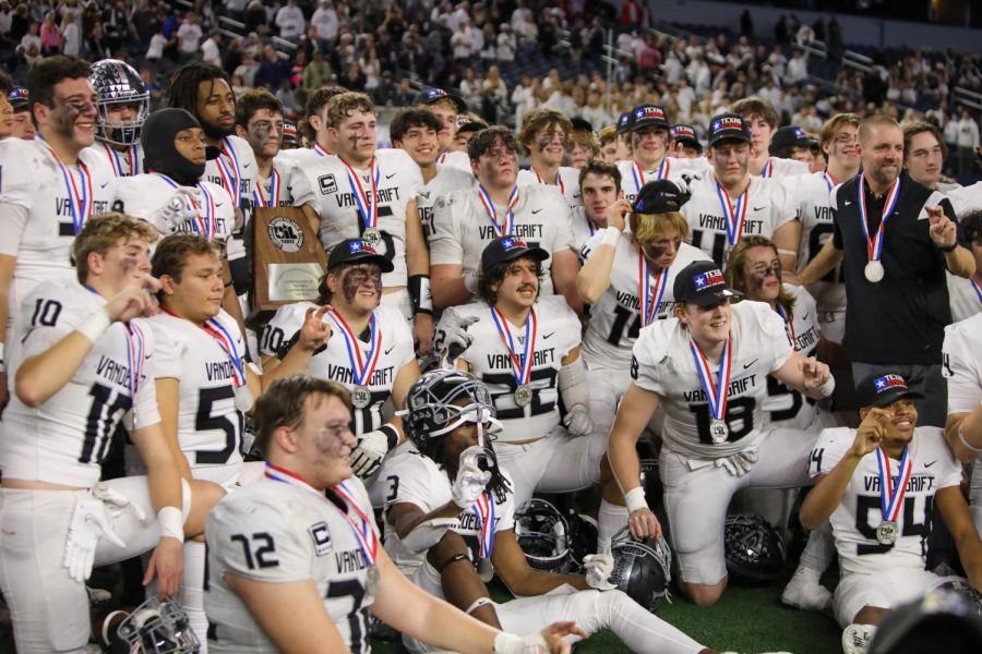 The players pose for one last picture in their gear on the field together with their final trophy to add to their collection.