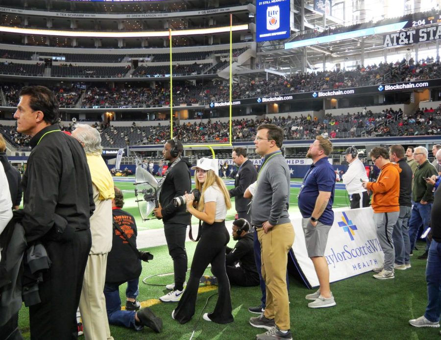 Clubs and teams editor of the yearbook, senior Kaya Kinsey tried to find some space amongst the overwhelming number of press and workers on the sideline. 