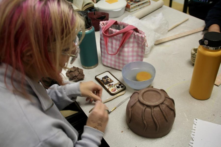 Senior Elise Barber works on her newest project, yet another pot with an undetermined purpose.