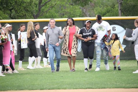 Senior Destiny Morgan walks onto field with family during senior night celebrations. 
