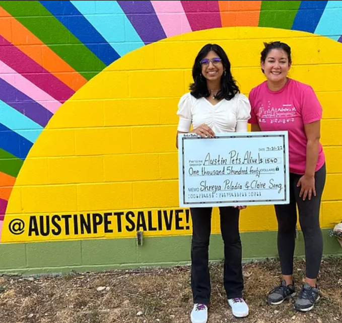 Shreya Poladia and business partner, Claire Song, hold their donation check to Austin Pets Alive, a nonprofit organization devoted to saving animals. Poladia and Song hosted the ArtnBake summer camp in July 2022 and donated all proceeds to the shelter. 