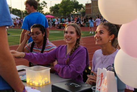Senior Inaya Jabbar, sophomore Josie Poinsett, and senior Sophia Peden encourage visitors to donate Iluminaria. Later in the event, the bags were lit up to form a cancer awareness ribbon.