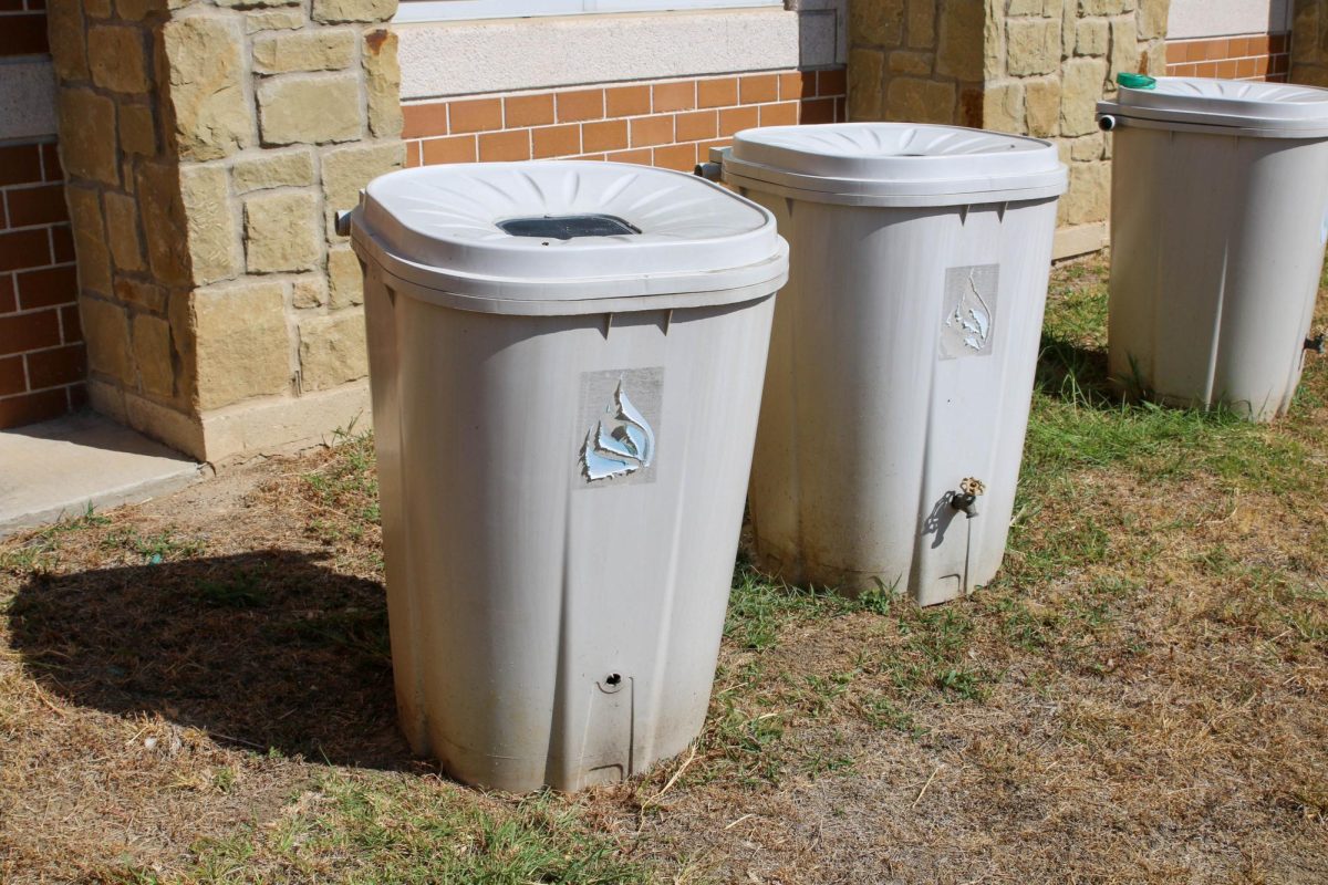 Rain collection barrels left over from a past school garden lie near the first building. The garden remains unattended as of 2023. 