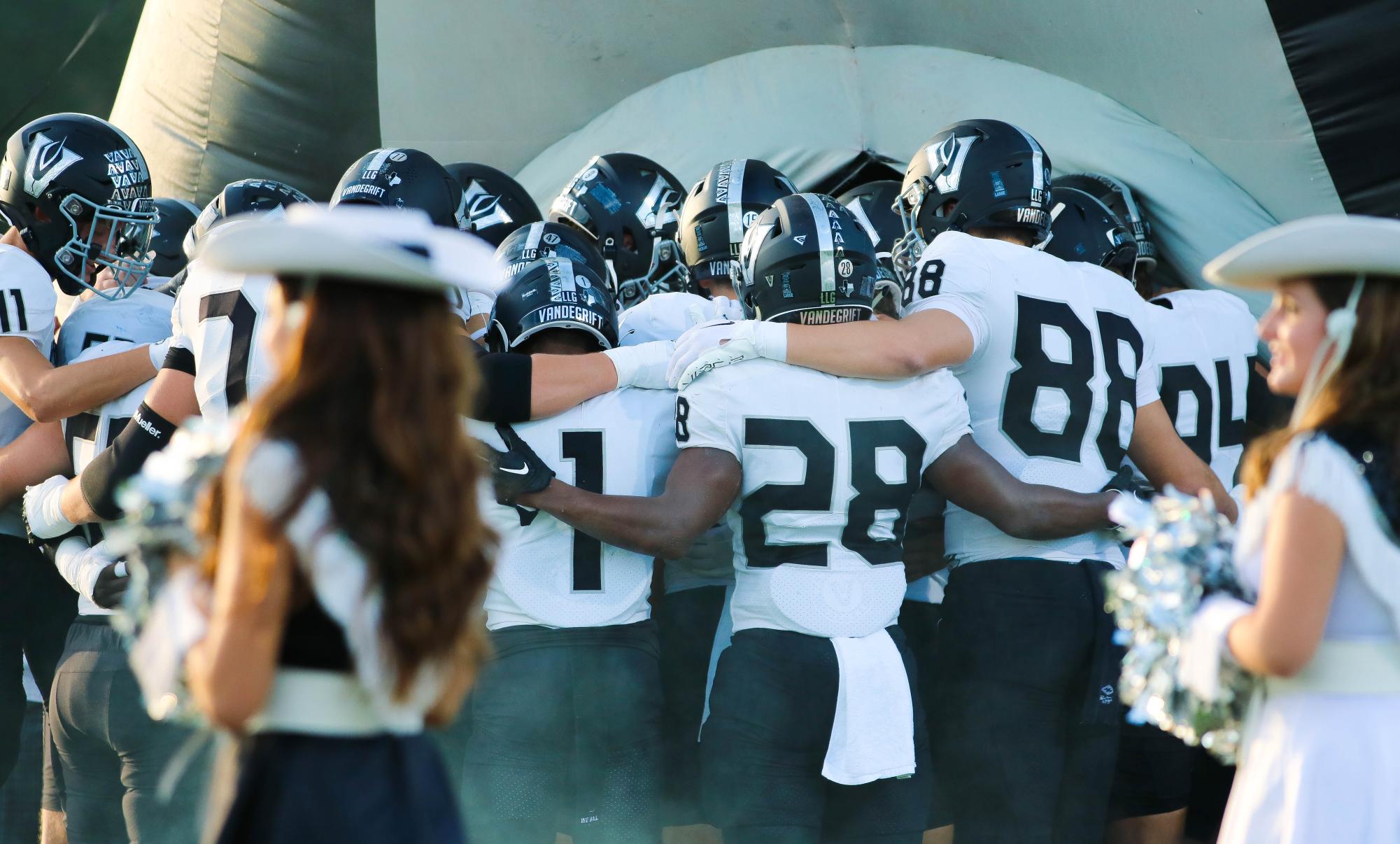 Varsity football prays in a huddle before running out of the Viper at Dragon Stadium to face Stoney Point. The team performs this tradition before every game.