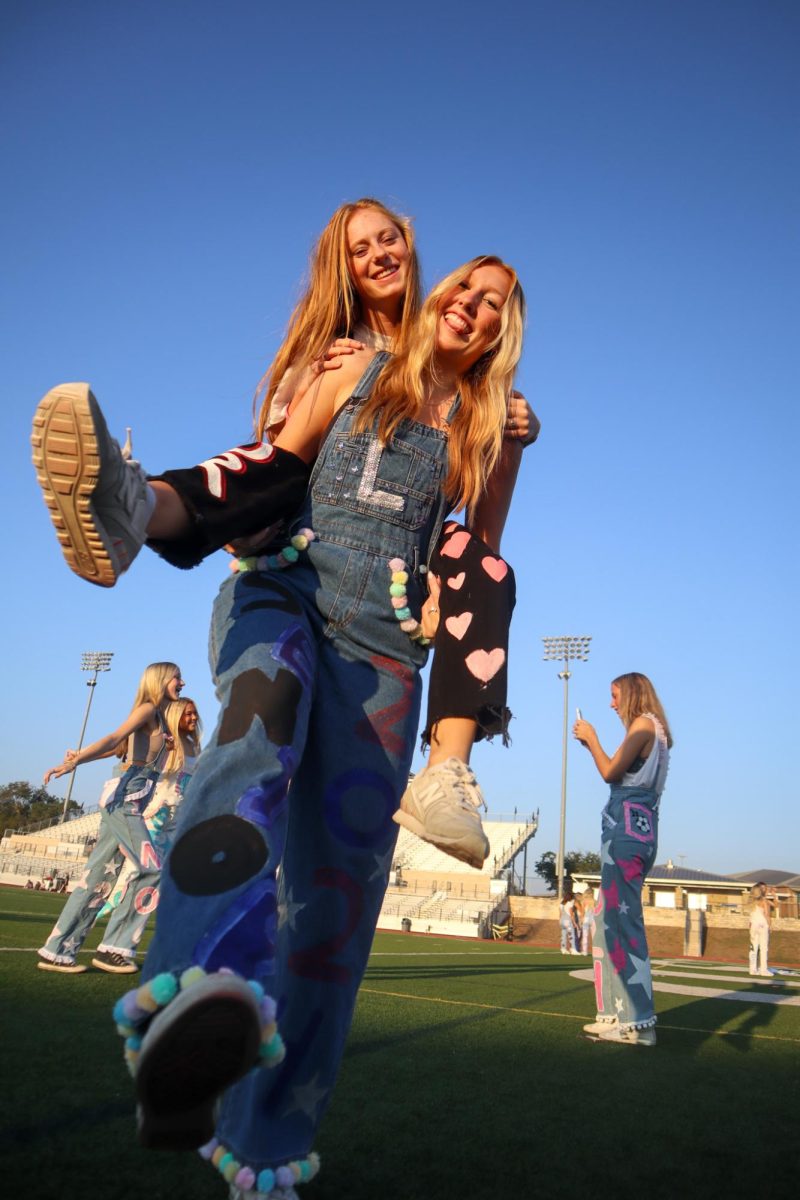 Seniors take pictures in their traditional overalls on Friday for Homecoming.